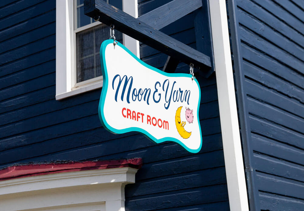 The Moon and Yarn painted sign hanging from the outside of the shop.